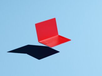 Conceptual image of a red laptop floating mid-air on a blue background with a hard shadow