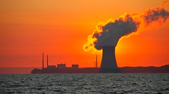 New York State wants more nuclear power in a big The sun rises behind a nuclear power plant cooling tower.